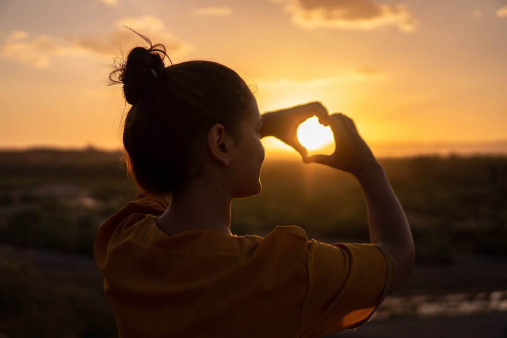 woman hands in shape of heart - travel trends